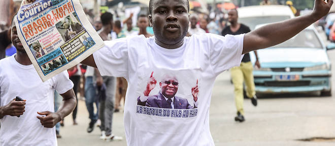 Un homme portant un tee-shirt sur lequel on peut lire "Le retour du fils dans le pays" celebre le 15 janvier 2019 a Abidjan l'annonce de l'acquittement de l'ancien president de la Cote d'Ivoire Laurent Gbagbo.