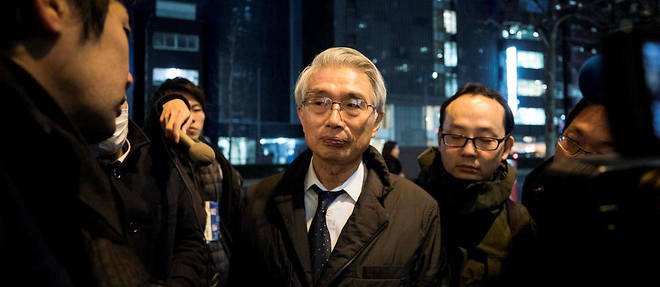 Junichiro Hironaka assailli par les journalistes a la sortie de ses bureaux, le 13 fevrier a Tokyo.  