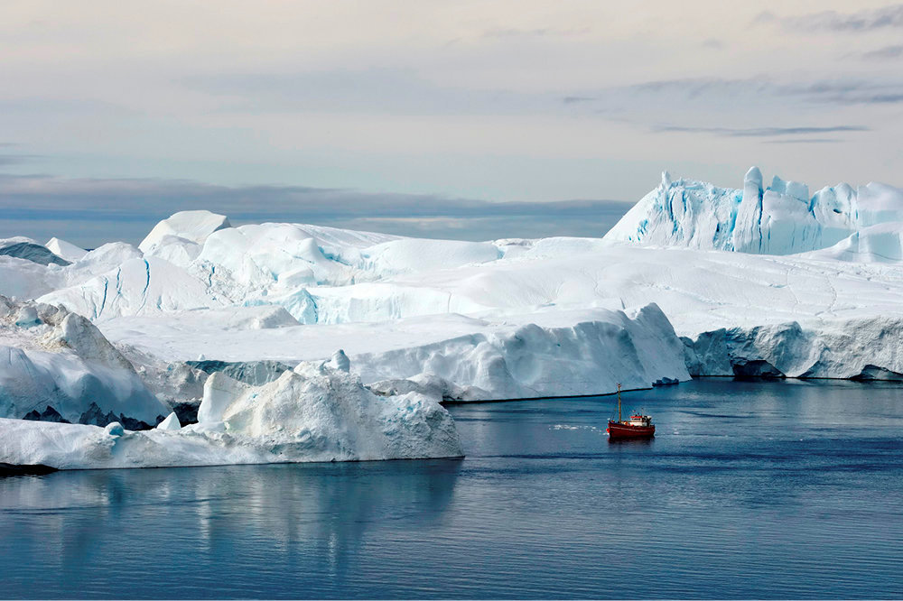 Un petit bateau de peche s'avance le long du glacier d'Ilulissat, dans la baie de Disko, a l'ouest du Groenland.Le fjord glace est classe au Patrimoine mondial de l'Unesco depuis 2004.