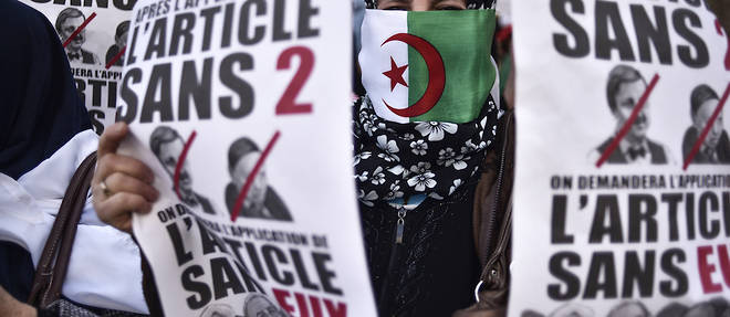 A protester holds placards during a demonstration against ailing President Abdelaziz Bouteflika in the capital Algiers on March 29, 2019. - Opposition to Bouteflika has been widening since the chief of staff, General Ahmed Gaid Salah on March 26, 2019 invoked Article 102 of the constitution under which a president can be removed if found unfit to rule. (Photo by RYAD KRAMDI / AFP)