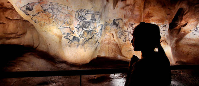 Une grande fresque tracee au charbon il y a 36 000 ans au fond de la grotte Chauvet represente un groupe de lions chassant des bisons. Un petit rhinoceros a ete ajoute au bas de la scene.