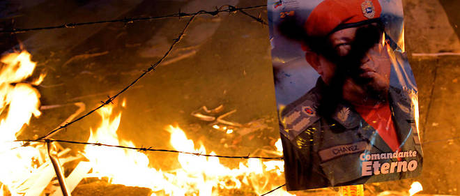 Un portrait de Chavez est jete au feu lors d'une manifestation anti-Maduro en 2014 a Caracas.
