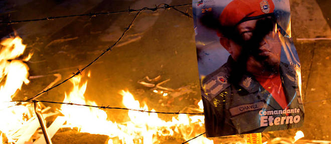 Un portrait de Chavez est jete au feu lors d'une manifestation anti-Maduro en 2014 a Caracas.