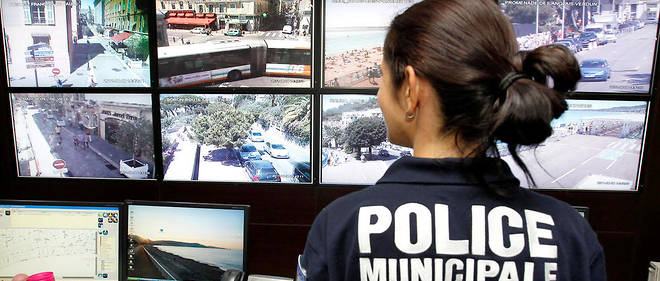 Une policiere municipale controle les ecrans de surveillance dans le centre de videosurveillance de la police municipale de Nice, en 2001. 