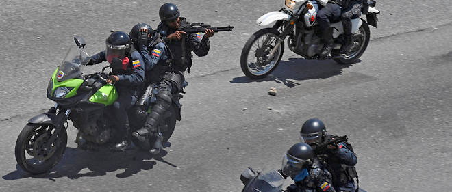 La << police nationale bolivarienne >> ouvre le feu sur des manifestants anti-Maduro le 30 avril 2019 aux abords de la base militaire La Carlotta a Caracas.
