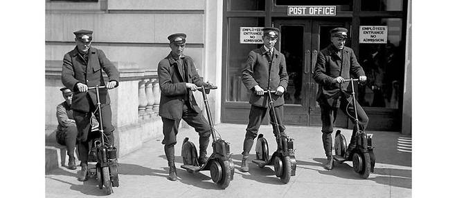Des postiers americains essayant leurs nouvelles trottinettes motorisees dans les annees 1910.