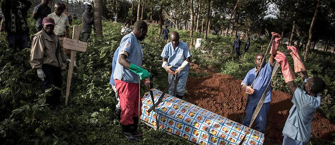Des personnels de sante enterrent un cercueil a Butembo, epicentre de l'epidemie d'Ebola, le 16 mai 2019. 