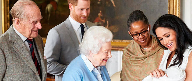 La reine Elizabeth, le 8 mai 2019, aux cotes de sa famille. Dans les bras de Meghan Markle, le petit dernier de la lignee, Archie. 
 