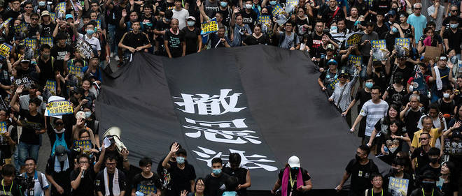 Selon les organisateurs, 115 000 personnes ont defile dimanche 14 juillet  dans une ville situee pres de la frontiere entre Hong Kong et la Chine,