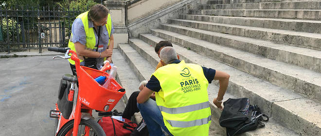 Des agents de l'Unite d'assistance aux sans-abri de la mairie de Paris distribuent des gourdes d'eau lors d'une maraude en pleine canicule mercredi 24 juillet.