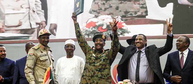 Le leader de la protestation soudanaise Ahmad Rabie aux cotes du general Abdel Fattah al-Burhan, chef du Conseil militaire transitoire au pouvoir au Soudan, lors d'une ceremonie marquant la "declaration constitutionnelle" en presence du Premier ministre ethiopien Abiy Ahmed (a gauche), du president sud-soudanais Salva Kiir (a droite de l'arriere), le president tchadien Idriss Deby (a la troisieme place) et le president du Kenya, Uhuru Kenyatta (a droite). 