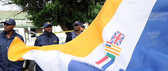 Des policiers encadrent une manifestation ou le drapeau de l'epoque de l'apartheid a ete deploye. 