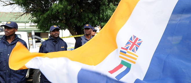 Des policiers encadrent une manifestation ou le drapeau de l'epoque de l'apartheid a ete deploye. 