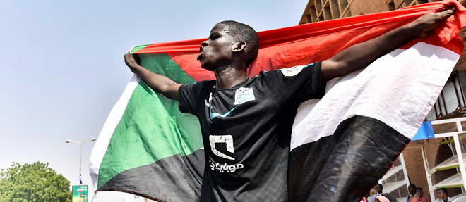 Un jeune Soudanais porte un drapeau a Omdourman lors d'une marche de solidarite pour Ahmed al-Kheir, enseignant mort en detention apres son arrestation en janvier.