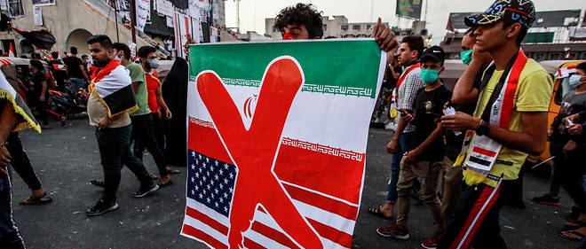 Un manifestant irakien brandit une pancarte oppose a la Republique islamique d'Iran et aux Etats-Unis, le 3 novembre 2019 sur la place Tahrir de Bagdad. 
