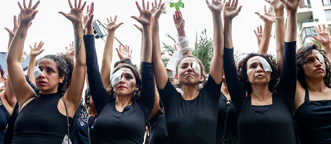 Des femmes habillees en noir avec un oeil bande pour rendre hommage aux blesses lors des manifestations au Chili.