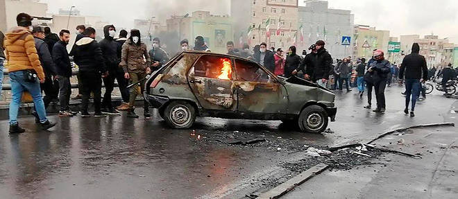 Des manifestants iraniens sont rassembles autour d'une voiture en feu pour protester contre la hausse soudaine du prix de l'essence, le 16 novembre 2019 a Teheran.
 