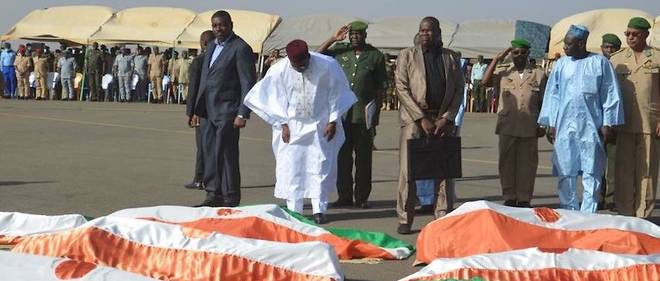 Le president Issoufou a decore chacun des soldats tombes a Inates lors de la levee des corps a la base aerienne 101 de Niamey.

