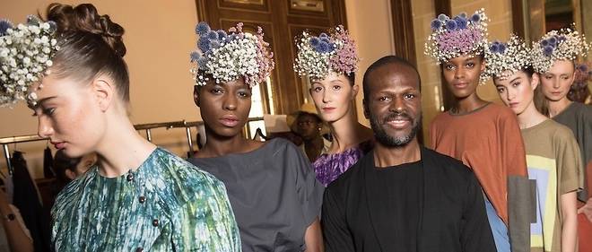 Si Imane Ayissi est un habitue des Fashion Weeks africaines, il presente aussi ses collections a Paris chaque ete, pendant la Semaine de la couture. Ici en 2017 pour le final entoure des mannequins. 
