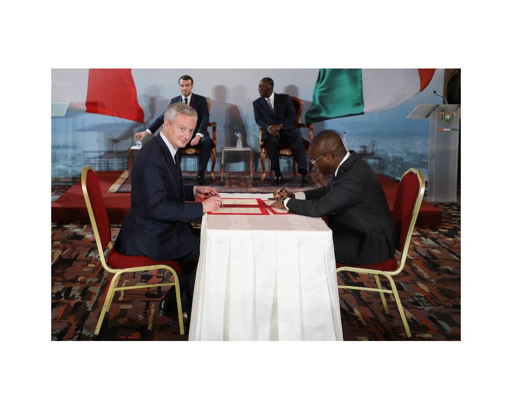 <p>Le ministre français de l'Économie et des Finances, Bruno Le Maire (G), et le ministre de l'Économie du Bénin, Romuald Wadagni, signent l'accord de réforme de la monnaie CFA en présence du président français, Emmanuel Macron, et du président Alassane Ouattara au palais présidentiel à Abidjan le 21 décembre 2019.</p>
 ©  LUDOVIC MARIN / AFP