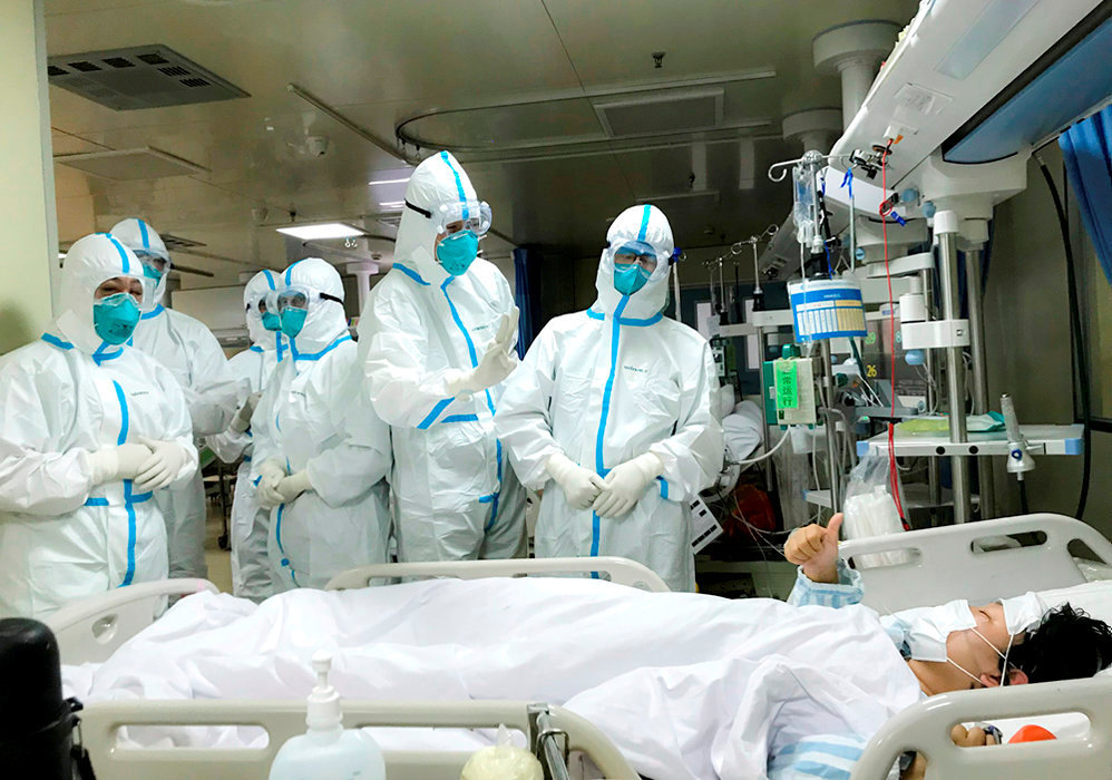 
        Urgence. Des membres de l'equipe medicale de la deuxieme universite de medecine militaire avec un patient atteint du nCoV a l'hopital Hankou de Wuhan, le 27 janvier.