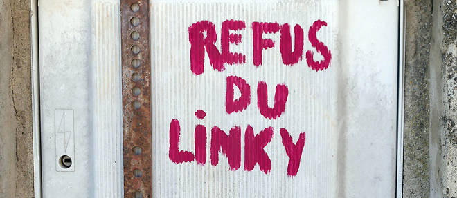 Ancien compteur electrique EDF devant la maison d'un village francais, verrouille en 2018 par le proprietaire de la maison pour empecher son remplacement par un compteur Linky.

