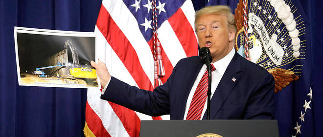 
Le president americain Donald Trump montrant une photo du mur frontalier avec le Mexique lors de son allocution aux membres du Conseil national de patrouille des frontieres a la Maison-Blanche, le 14 fevrier 2020,  a Washington.

