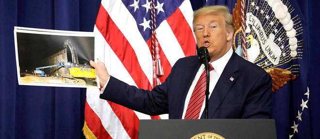 
Le president americain Donald Trump montrant une photo du mur frontalier avec le Mexique lors de son allocution aux membres du Conseil national de patrouille des frontieres a la Maison-Blanche, le 14 fevrier 2020,  a Washington.
