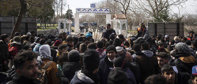 Des migrants masses le 2 mars a la frontiere greco-turque devant le point de passage de Pazarkule pres d'Edirne tentent de penetrer sur le territoire europeen. 
