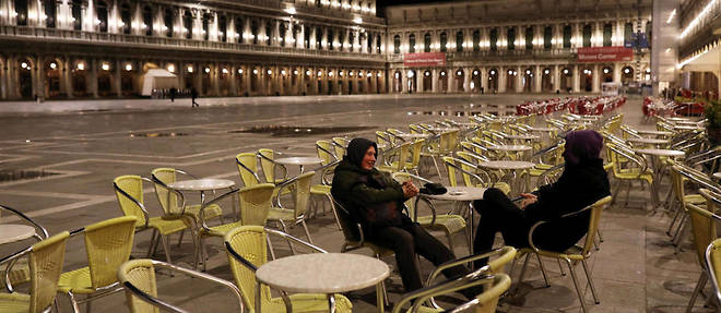 Deux touristes sur la place Saint-Marc desertee a Venise, le 8 mars. Les regions de la Lombardie et de la Venetie sont en quarantaine pour tenter de limiter la propagation du coronavirus.
