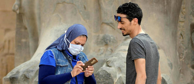 Lors d'une visite au temple de Louxor, le 9 mars 2020, une touriste porte un masque de protection respiratoire. 
