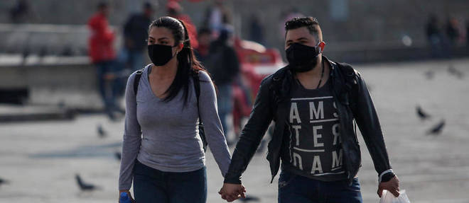 Un couple de Colombiens portant un masque a Bogota le 19 mars 2020.
