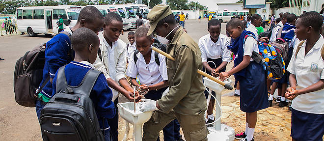 Les eleves du secondaire au Rwanda se lavent les mains au point de lavage temporaire avant de rentrer chez eux apres que les autorites ont ferme tous les internats.
