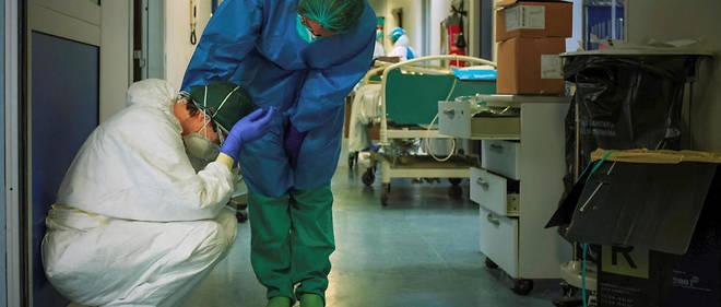 A nurse wearing protective mask and gear comforts another as they change shifts on March 13, 2020 at the Cremona hospital, southeast of Milan, Lombardy, during the country's lockdown aimed at stopping the spread of the COVID-19 (new coronavirus) pandemic. - After weeks of struggle, they're being hailed as heroes. But the Italian healthcare workers are exhausted from their war against the new coronavirus. (Photo by Paolo MIRANDA / AFP) / RESTRICTED TO EDITORIAL USE - MANDATORY CREDIT "AFP PHOTO / PAOLO MIRANDA" - NO MARKETING - NO ADVERTISING CAMPAIGNS - DISTRIBUTED AS A SERVICE TO CLIENTS