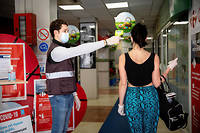 Un employé de Carrefour Market à Cannes prend la température des clients avec un thermomètre laser durant l'épidémie de coronavirus et le confinement.
