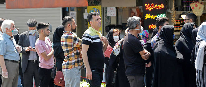 Une file d'Iraniens fait la queue derriere un marchand de change a Teheran le 9 mai 2020, sans respecter les regles de distanciation sociale vivement conseillees par le gouvernement (photo d'illustration).
