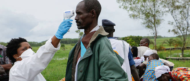 Le Burundi a tres tot ferme ses frontieres en raison de la pandemie du coronavirus. Des Burundais se lavent les mains a la frontiere a l'arrivee de leur rapatriement de la RDC le 1er mars 2020.
