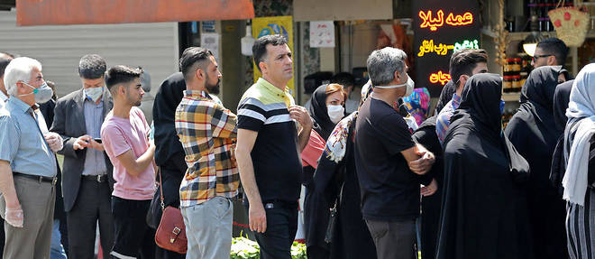 Une file d'Iraniens fait la queue derriere un marchand de change a Teheran le 9 mai 2020, sans respecter les regles de distanciation sociale vivement conseillees par le gouvernement (photo d'illustration).
