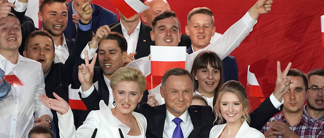 Le president polonais Andrzej Duda fait le "V" de la victoire en compagnie de son epouse et de sa fille apres l'annonce de sa victoire a l'election du 12 juillet.  
