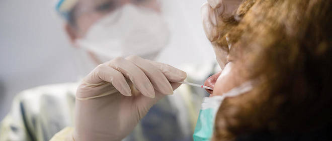 Un membre du personnel medical effectuant un test PCR nasal.
