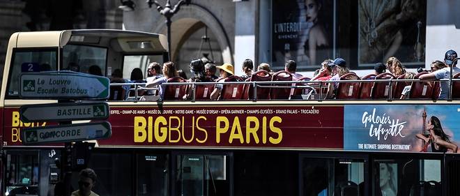 Des touristes visitent Paris le 6 aout 2020 a bord d'un bus a double etage 
