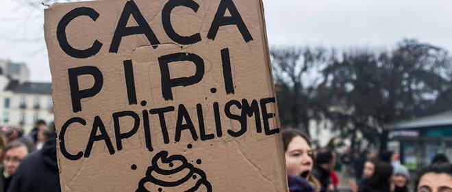 Un homme tient une pancarte << caca-pipi-capitalisme >> lors de la manifestation du 34e jour de greve generale contre la reforme des retraites, le 9 janvier 2020, a Nantes.
