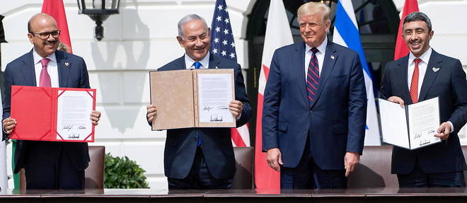 Les ministres des Affaires etrangeres du Bahrein, Abdullatif al-Zayani (a gauche), le Premier ministre israelien Benyamin Netanyahou et le chef de la diplomatie emirienne Abdullah bin Zayed Al-Nahyan (a droite) signent les accords d'Abraham en presence de Donald Trump le 15 septembre a Washington. 
