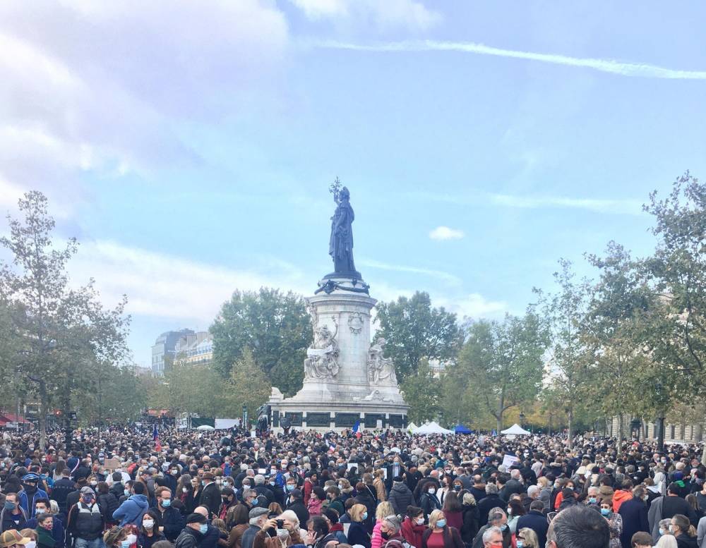 Place de la République, une foule dense écoute les discours d'hommage à l'enseignant assassiné vendredi après-midi dans les Yvelines.
  