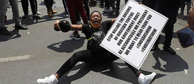 Une Nigeriane basee en Afrique du Sud hurle en manifestant devant son ambassade a Pretoria le 21 octobre 2020 en solidarite avec la jeunesse nigeriane qui reclame la fin de la brutalite policiere.
