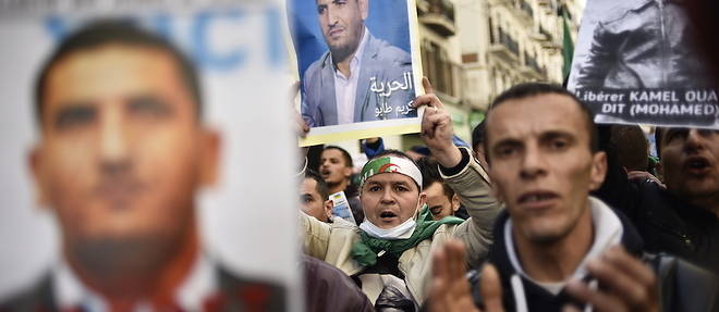 Des manifestants portent le portrait de Karim Tabbou, accuse d'atteinte au moral de l'armee, en janvier 2020.

