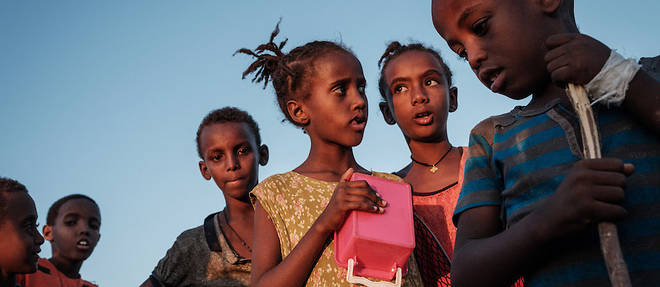 Des enfants ehiopiens qui ont fui le Tigre attendent que de la nourriture leur soit distribuee devant un entrepot du camp de refugies d'Um Raquba a Gadaref, dans l'est du Soudan, le 1er decembre.

