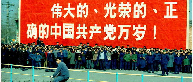 Foule devant un poster de propagande proclamant : << Vive le grand, glorieux et infaillible Parti communiste chinois >>, en 1972.
