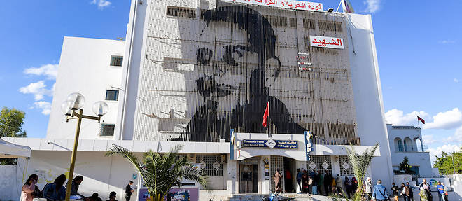 La ville tunisienne de Sidi Bouzid a joue un role cle dans le declenchement d'une vague de revoltes dans le monde arabe il y a 10 ans. Ici la place a ete rebaptisee du nom de Mohammed Bouazizi avec sur la facade un dessin de son visage. 
