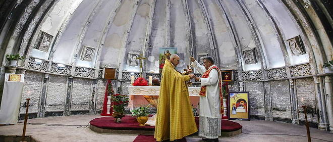 Un pretre irakien celebre la messe de Noel dans l'eglise de Qaraqosh, qui avait ete partiellement detruite par Daech.

